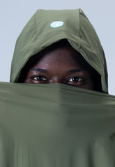 Black man looking at camera with a green hood | Save The Duck