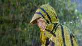 Joyful woman in an animal-friendly, leopard-print, waterproof jacket relishing a rainy day | Save The Duck | Animal Free Elegant Duvets for Men and Women
