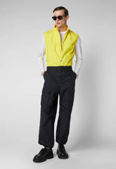 Man wearing yellow recycled polyester vest with black cargo pants and sunglasses | Save The Duck | Animal Free Elegant Duvets for Men and Women