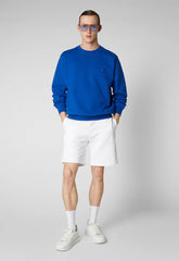 Man wearing blue recycled polyester sweatshirt with white shorts and sneakers | Save The Duck | Animal Free Elegant Duvets for Men and Women