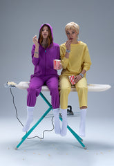 Two girls sitting on a iron board eating pop corn | Save The Duck