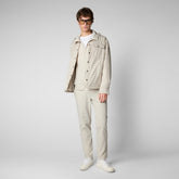 Man wearing light beige recycled polyester jacket and pants with white sneakers | Save The Duck | Animal Free Elegant Duvets for Men and Women