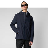 Man wearing navy blue recycled polyester hooded jacket with black pants and sunglasses | Save The Duck