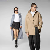 Chic couple showcasing sustainable fashion with a long grey trench coat and a classic beige jacket, both from animal-friendly materials | Save The Duck | Animal Free Elegant Duvets for Men and Women