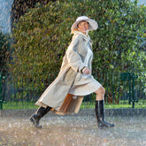 Women running in the rain with a long beige rain coat | Sauvez le canard